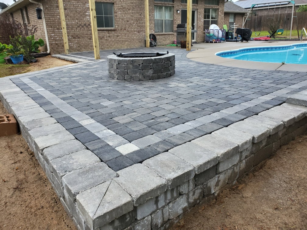 raised surface pavers with firepit next to pool