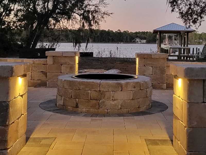 fire pit with seating area and accent lighting